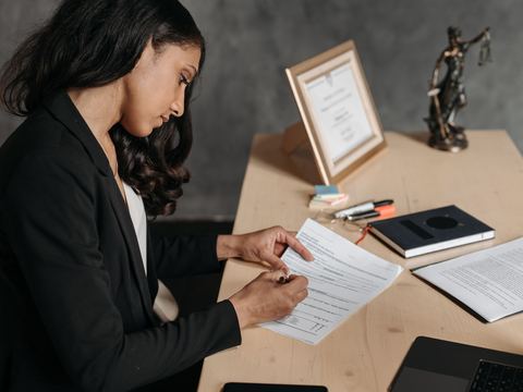 Advogada revisando documentos à mesa de um escritório